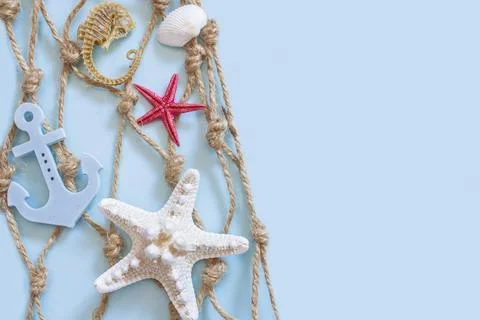 Fishing net on the right side of the image, with a white and a red starfish, Stock Photos