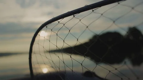 Fishing net on smooth river water with fishing boats at sunset Stock Footage 101011048