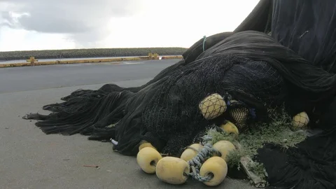 Fishing nets are lying on seacoast in fishery town, static plan outdoor Stock Footage 71335203