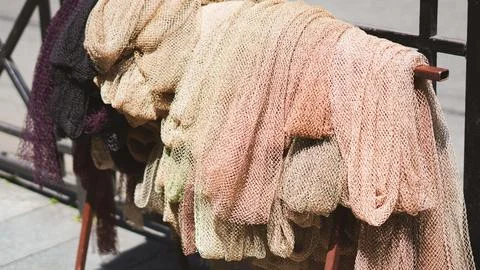 Fishing nets drying on a metal rack outdoors. Stock Photos