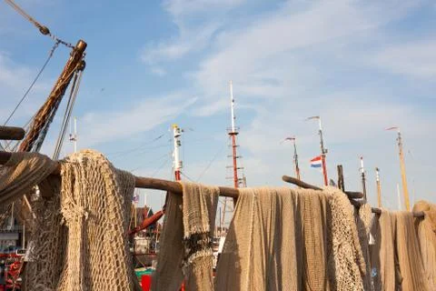 Fishing nets drying in the sun alongside the harbour Stock Photos