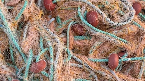 Fishing nets intertwined with ropes and floats create a textured, colorful .. Stock Footage 330397337