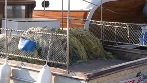 Fishing nets lie on the deck of a moored fishing boat Stock Footage 228937860