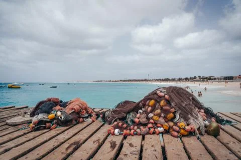 Fishing Nets on Pier with Ocean and Beach in the background on a cloudy day Stock Photos