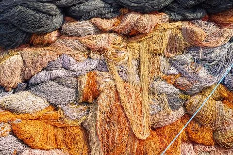Fishing nets stack or heap in the fishing harbor. Stock Photos