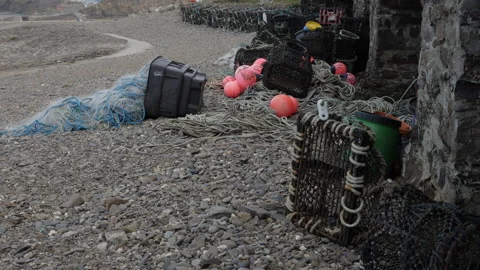 Fishing pots on a pebble beach Stock Footage 233900074