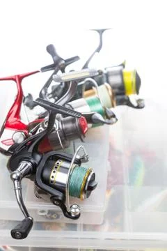 Fishing reels on storage boxes with baits Stock Photos