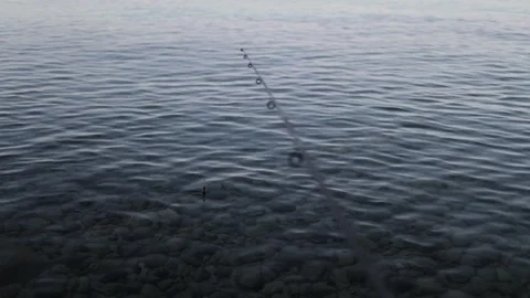 Fishing rod and float on calm sea water while waiting for a fish to bite Stock Footage 341622422