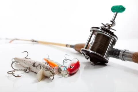 Fishing rod and three lures on a white background Stock Photos