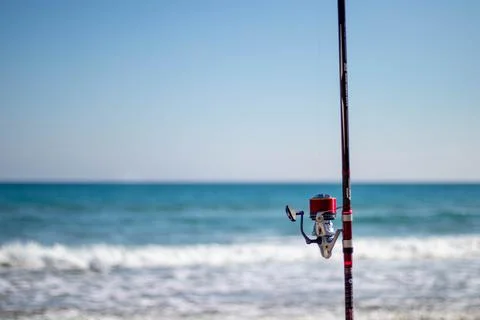 Fishing rod held in the sand while the fisherman fishes 写真素材