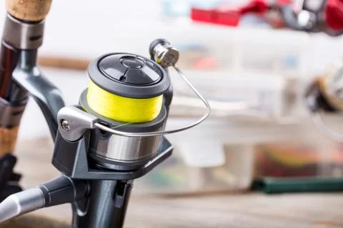 Fishing rod with reel on background of tackles in boxes Stock Photos