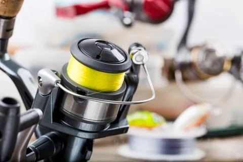 Fishing rod with reel on background of tackles in boxes Stock Photos