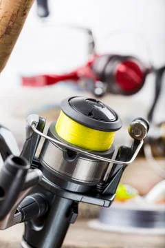 Fishing rod with reel on background of tackles in boxes Stock Photos