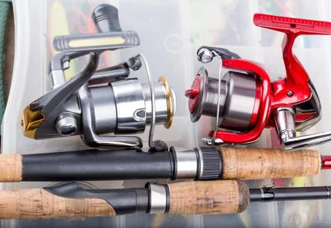 Fishing rod with reel on background of tackles in boxes Stock Photos