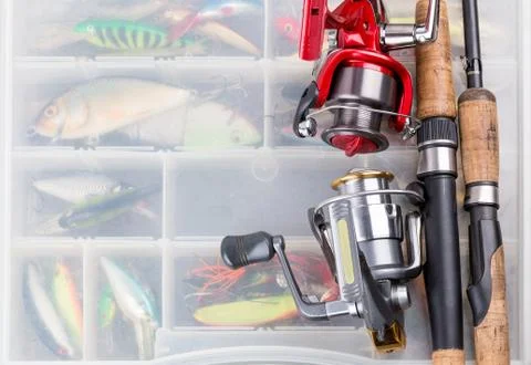 Fishing rod with reel on background of tackles in boxes Stock Photos