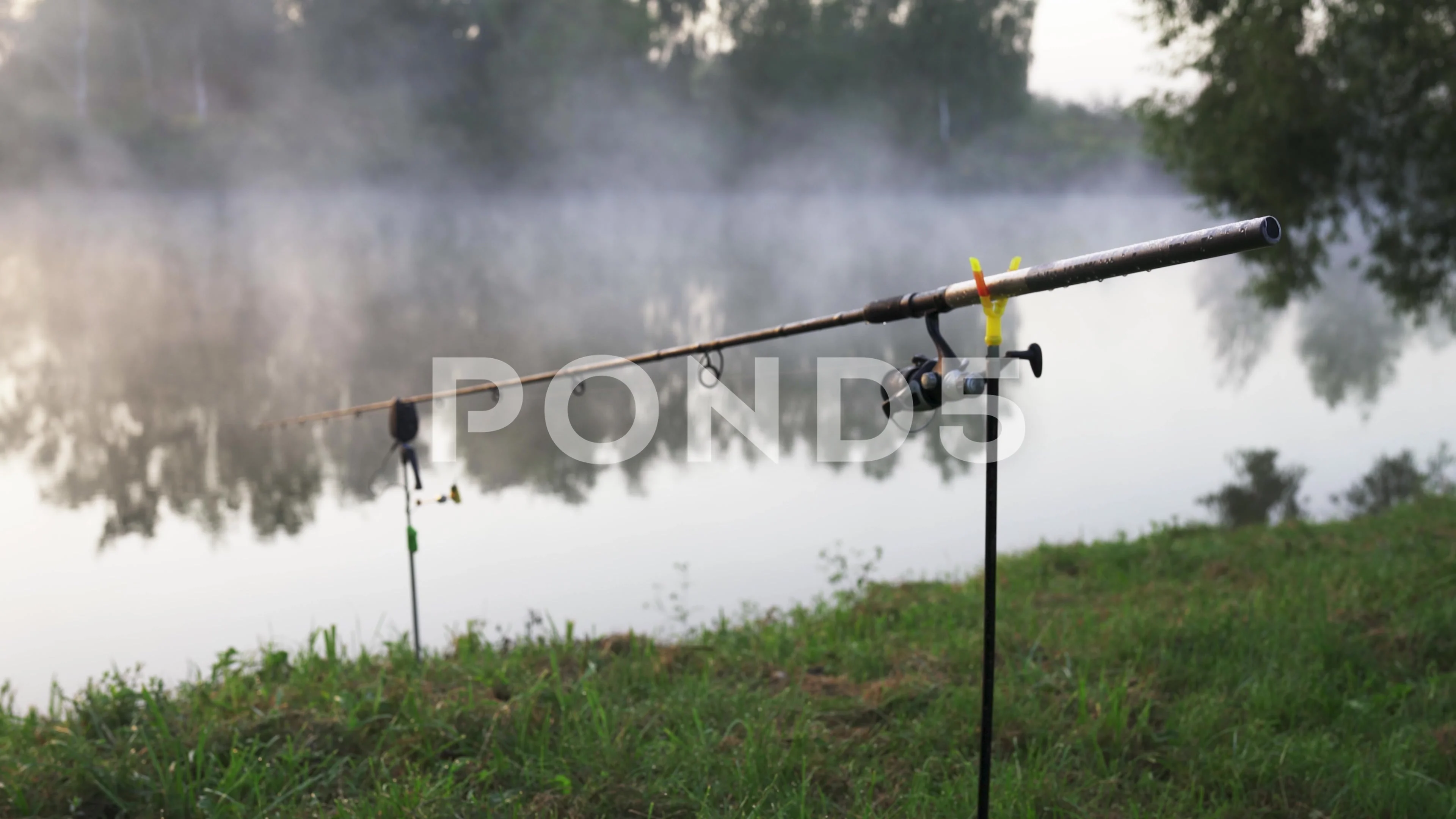 A fishing rod with a reel on which dew d, Stock Video