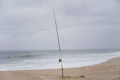 Fishing rod in sand on empty beach in Santa Cruz Portugal Stock Photos