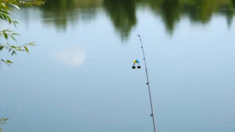 Fishing Rod Tip with Bells Bite Alarm Against Blue River Water Video stock 328356985