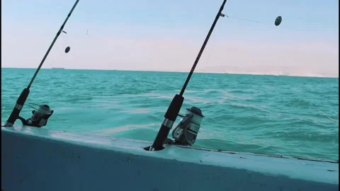 Fishing rods on a boat with many distant cargo ships on horizon Stock Footage 320090966