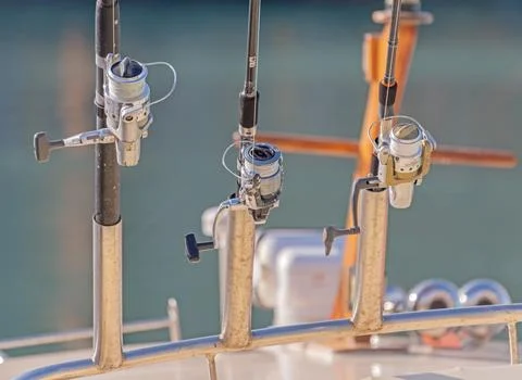 Fishing rods ready to fish on the deck of a fishing pleasure boat Stock Photos