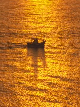 Fishing ship at sunset Stock Photos