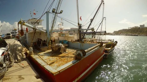 Fishing small ships pressed by the wind to the pier at the seaport Stock Footage 81698495