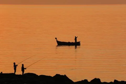 Fishing at sunset Stock Photos