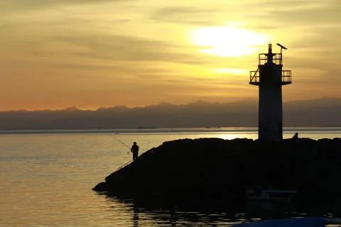 Fishing at sunset Stock Photos