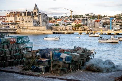 Fishing traps on dock with harbor boats behind Stock Photos