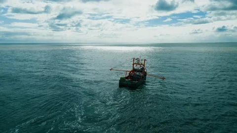 Fishing trawler, boat, ship sailing into the midday sun, trawling for fish .. Видео 236455865