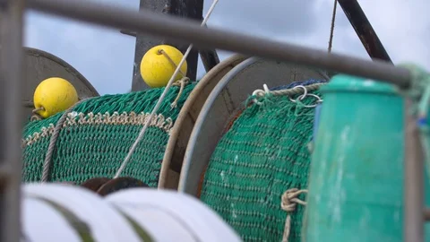 Fishing trawler green nets on large wheel spools on board boat Stock Footage 115546274