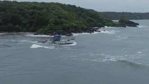 Fishing Trawler Navigating Choppy Seas Along Rocky Jungle Coastline in Goa 스톡 동영상 331226646