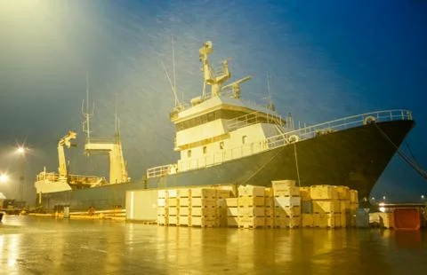Fishing trawler ship at dock by night in drizzling rain Stock Photos