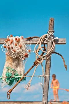 Fishnet with anchor in background with a little boy Stock Photos