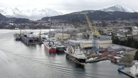 Fiskerstrand Shipyard beneath Snow Covered Mountains Stock Footage 346604075