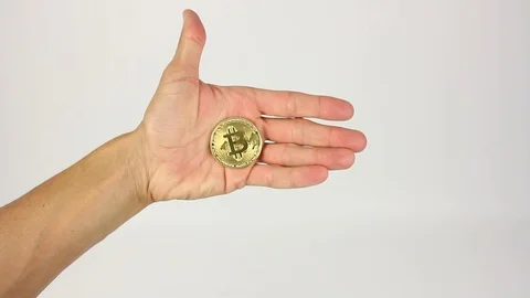 Fist clamped bitcoin appear in frame, opens palm and closes, white background Видео 92369947