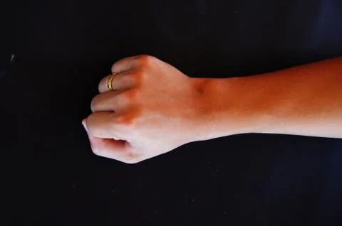Fist with a hand in the black background Stock Photos