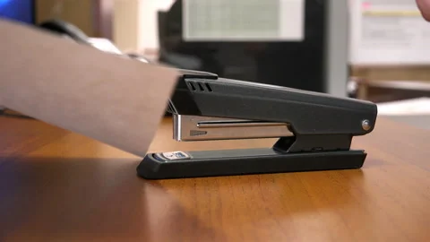 Fist presses stapler with paper clip Stock Footage 111584852