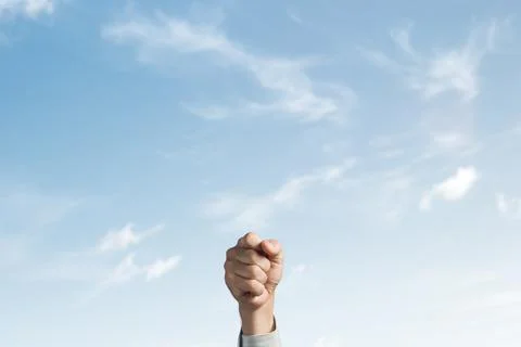 A fist raised. The sky in the background. Foto stock