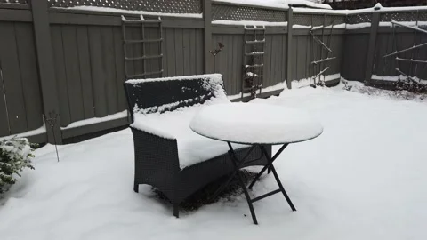Fist winter snow tracking shot of garden table and chair Stock Footage 144053043