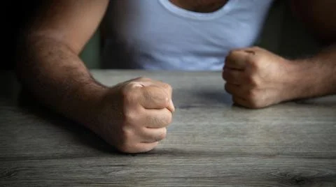 Fists of angry man beats on the table. Stock Photos