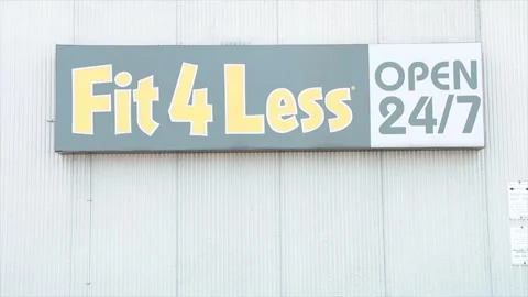 Fit 4 less open 24 7 gym sign logo exterior outside black yellow white on wall Stock Footage 252042260