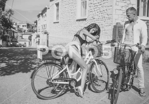 Fit and slim girl met handsome man on sunny day travelling by bicycle. Sexy Stock Photos