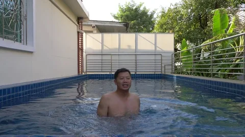 Fit asian man does back stroke in pool Stock Footage 81477754