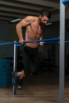Fit athlete doing exercise on parallel bars 스톡 사진