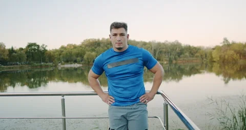 A Fit Athletic Man Posing by the Serene Lake Enjoying Fitness and Connecting Stock Footage 318074544