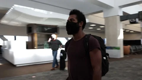 Fit Black Man Walks Through Airport Wearing Face Mask and Bag During COVID-19 Stock Footage 146164714