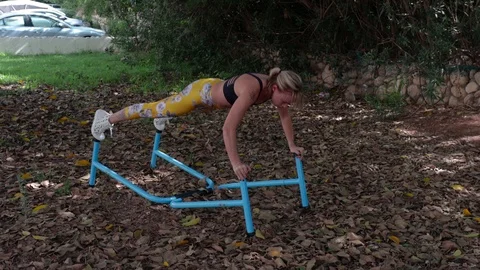 Fit blonde push-ups on parallel bars Stock Footage 115933610