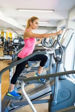 Fit blonde using the step machine Stock Photos