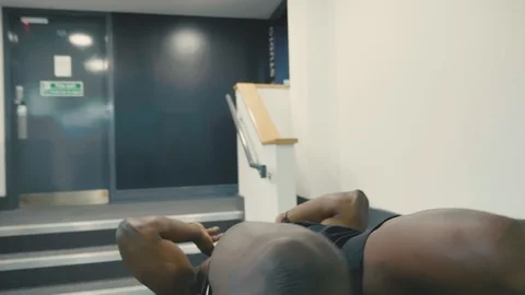 Fit Body builder does sit ups in gym on a decline bench Stock Footage 89578127